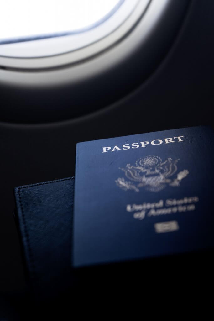 Passport in front of an airport window